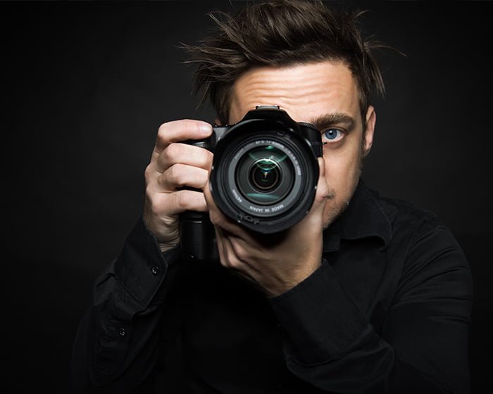 fotografer pria dengan kamera background hitam